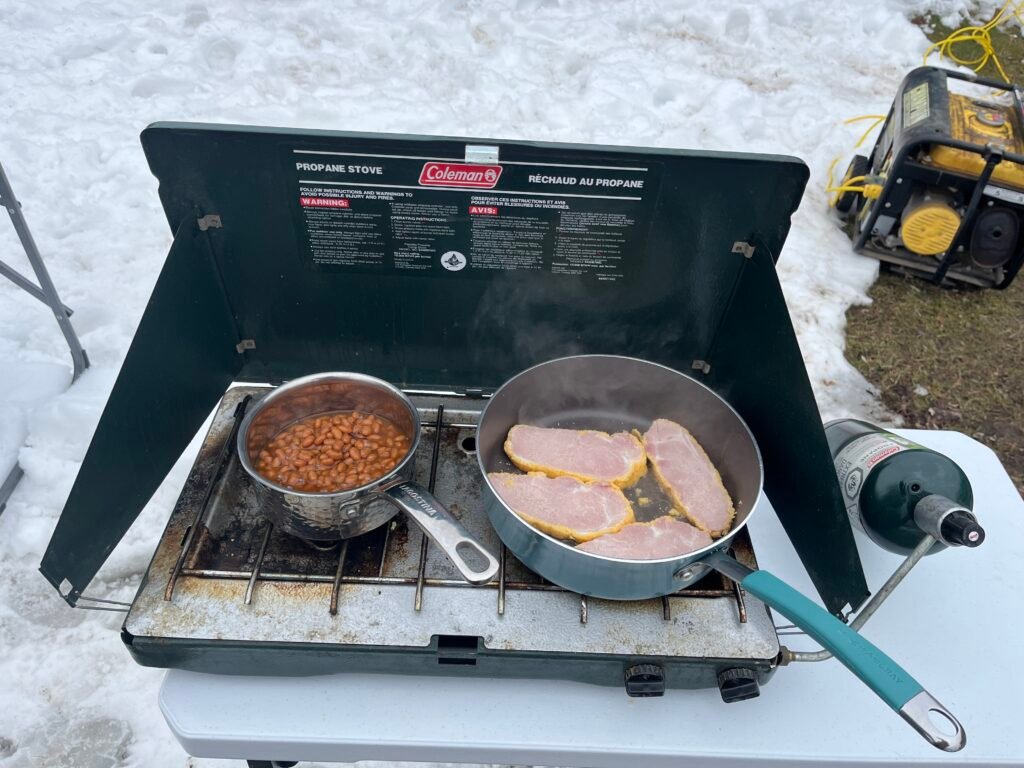 beans and pea meal bacon being cooked on a coleman stove 