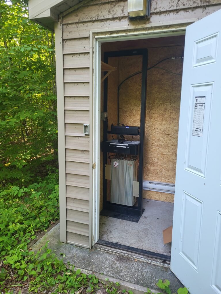 Wide shot of the repeater shack at VE3TJR with the door open.